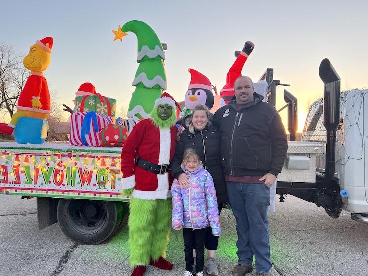 Vale family with the Grinch pose for a photo in front of the truck